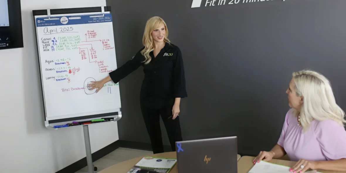 Two women at Fit20 reviewing a chart.